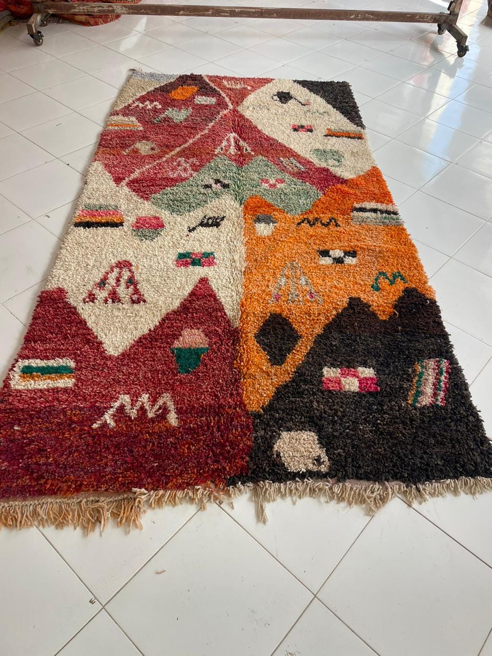 Lifestyle shot of a colorful vintage rug with varied patterns and fringed edges.