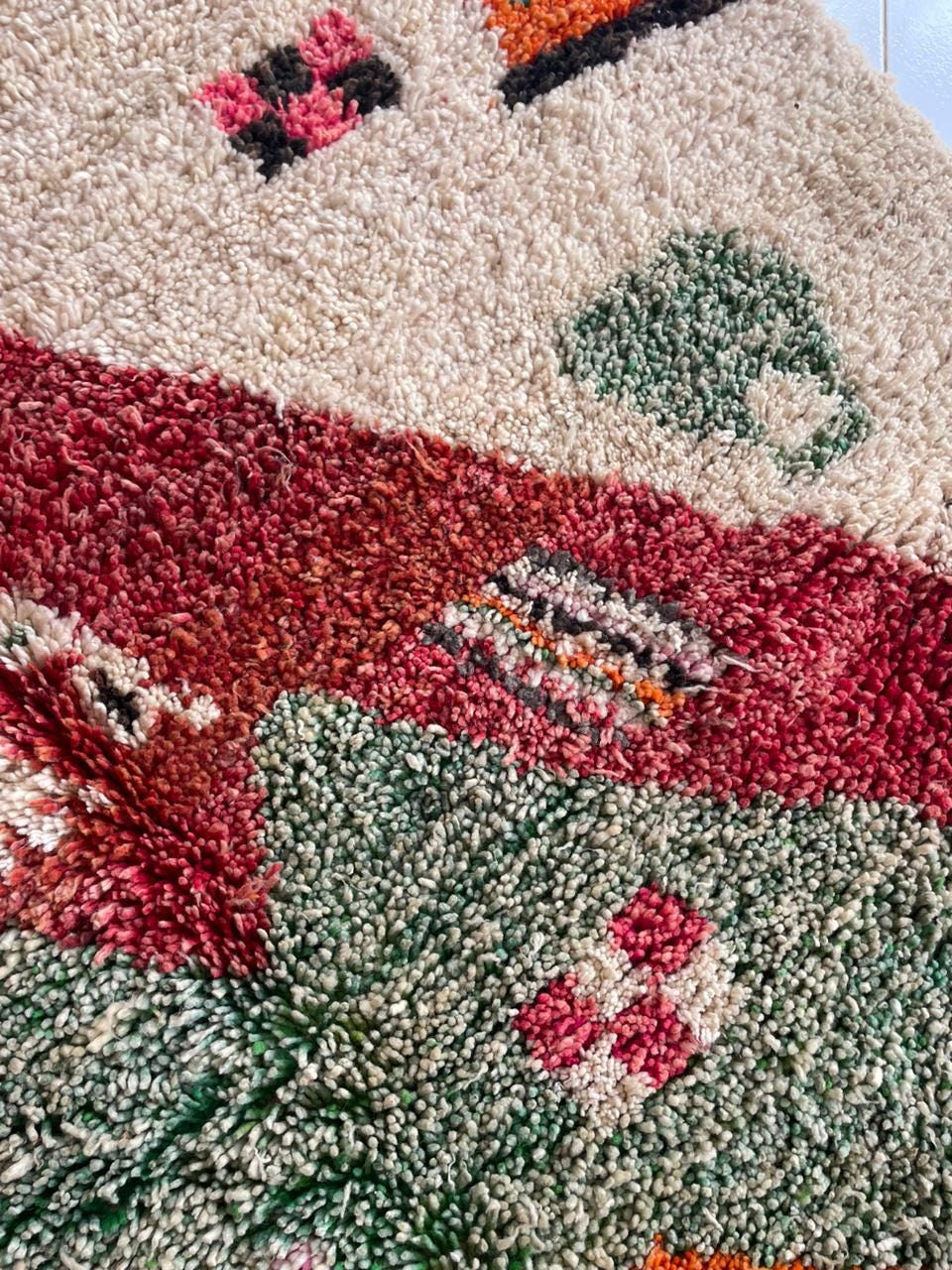Close-up detail of the fabric texture on the vintage Moroccan rug featuring colorful fibers.