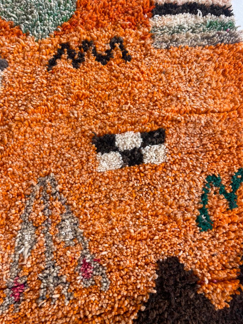 Close-up detail of the textured surface and decorative motifs on the vintage Moroccan rug.