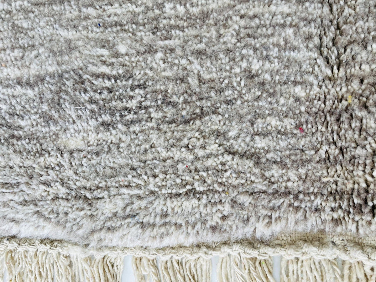 Close-up view of the tribal pattern on the red vintage Moroccan rug with gray and white tones.
