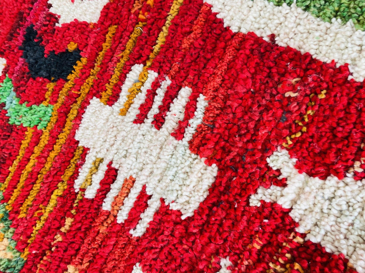 Detail view highlighting the tribal patterns and textures of a vintage Moroccan rug in red.