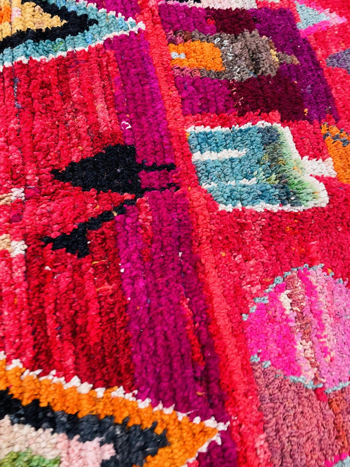 Detail view of a vintage Boujaad Moroccan rug in red and blue with tribal patterns and texture.