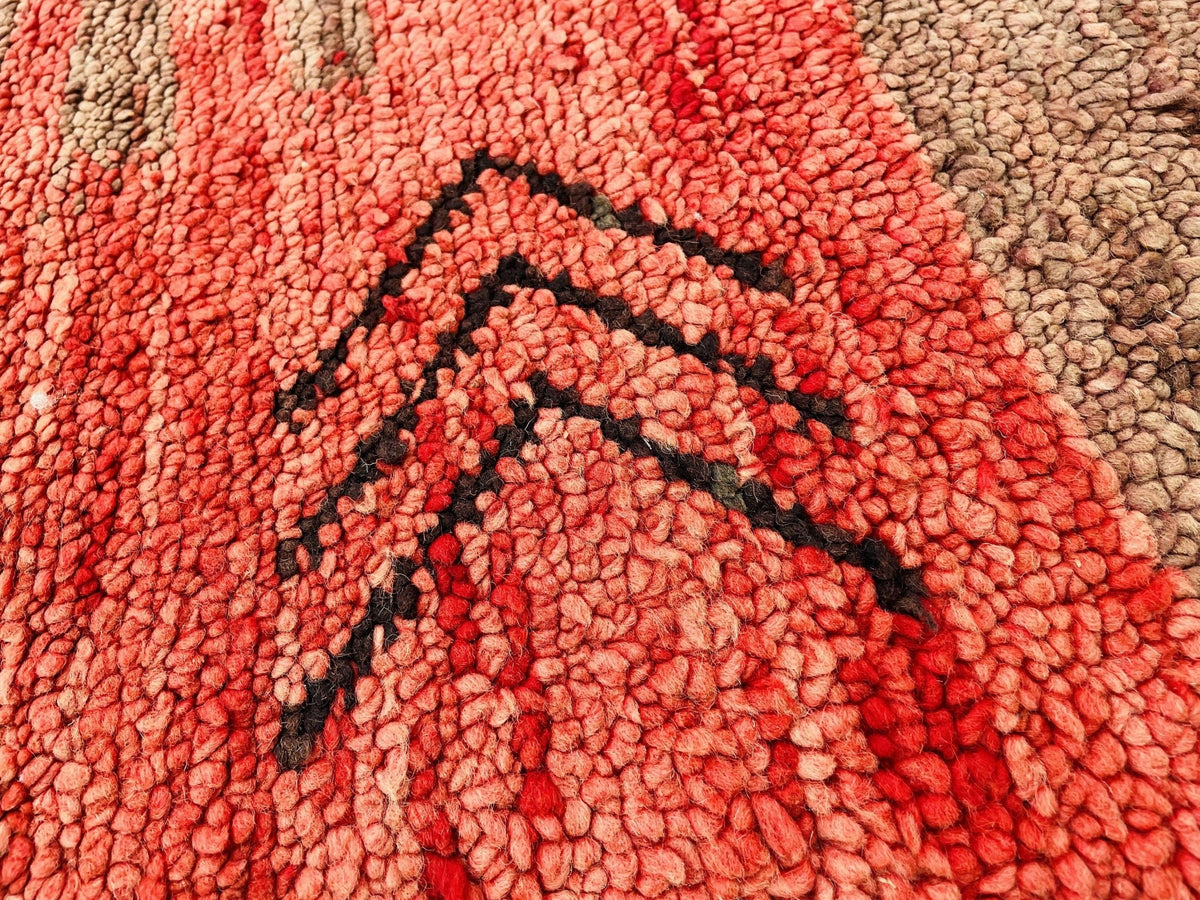Close-up detail of the tribal patterns and textured surface of the red vintage Boujaad Moroccan rug.