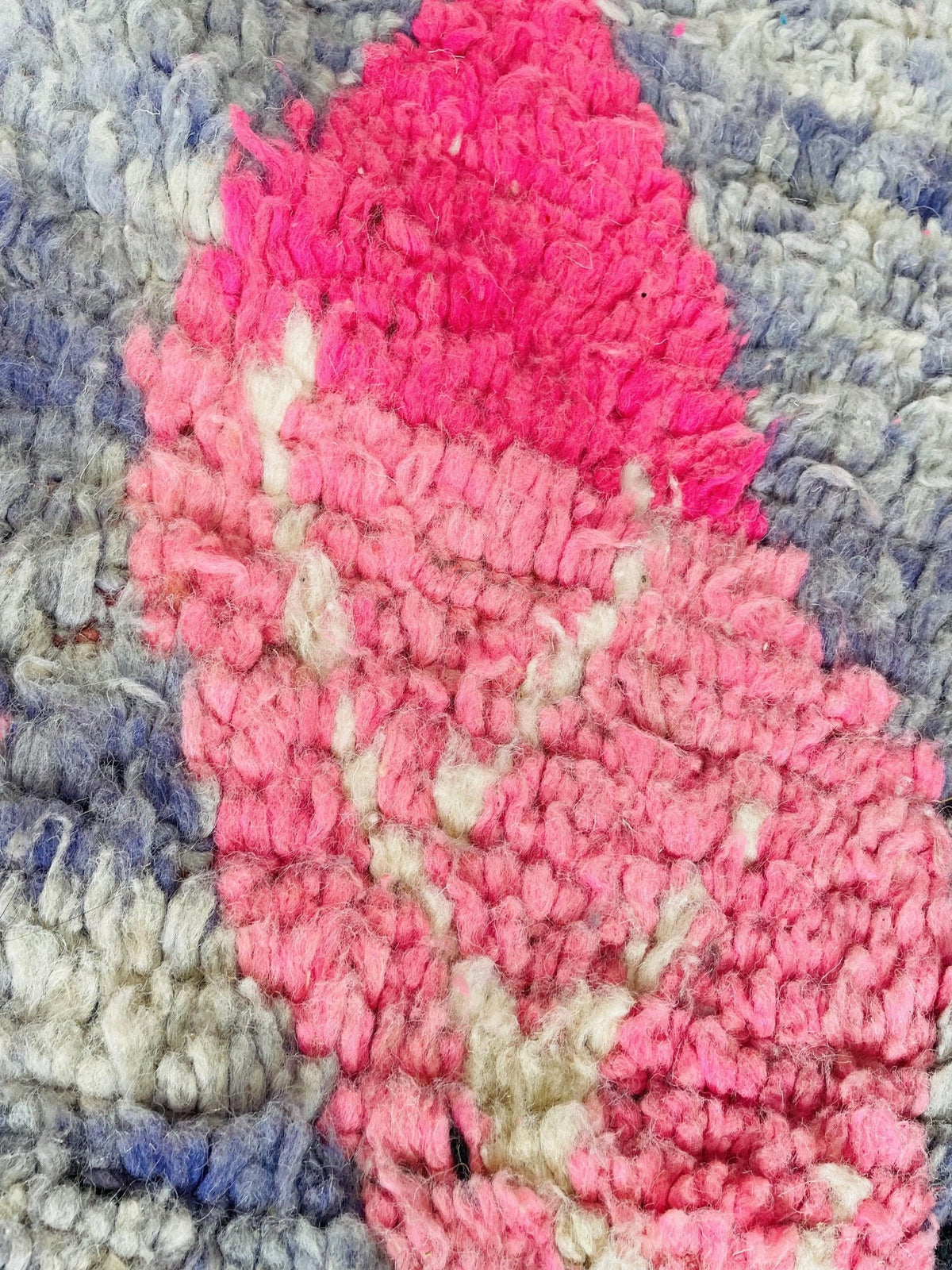 Close-up of a pink and blue vintage Boujaad Moroccan rug displaying its tribal design and texture.