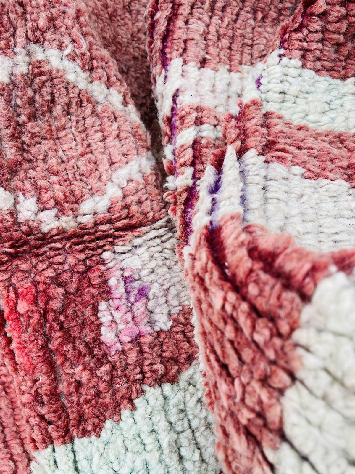 Close-up detail of the woven texture and color variations of a vintage Moroccan rug.