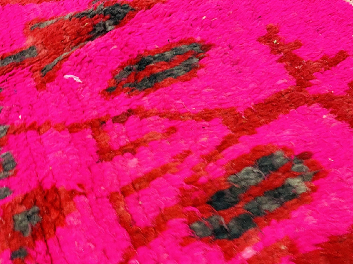 Detail shot of a pink and red vintage Boujaad Moroccan rug with tribal patterns.