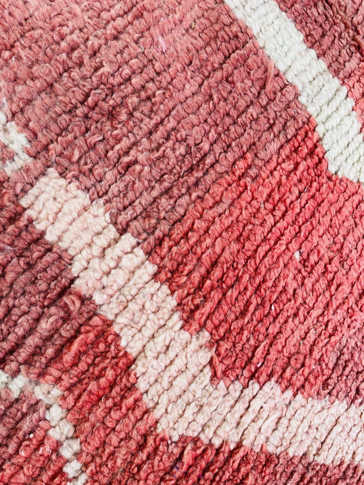 Close-up detail showcasing the woven texture and color patterns of a vintage Moroccan rug.