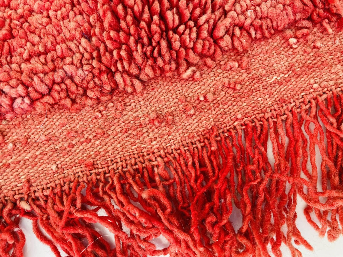 Detail shot highlighting the fringe and soft texture of the red vintage Boujaad Moroccan rug.