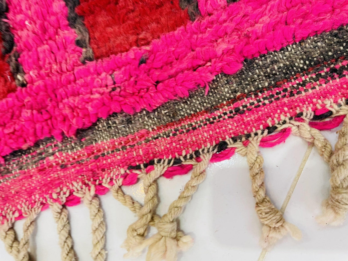 Detail view highlighting the fringe and colorful patterns of a red vintage Boujaad Moroccan rug.