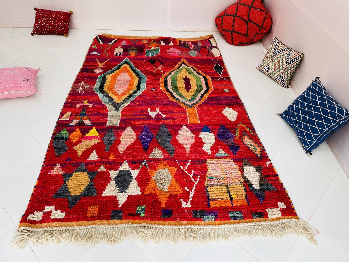 Lifestyle shot of a red vintage Boujaad Moroccan rug featuring fringe detail and tribal patterns.