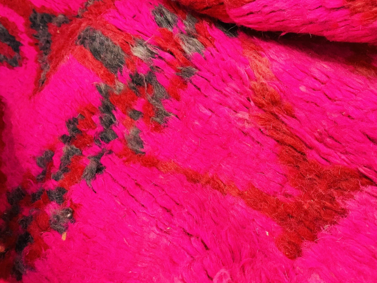 Detail view of a red vintage Boujaad Moroccan rug showcasing tribal patterns.