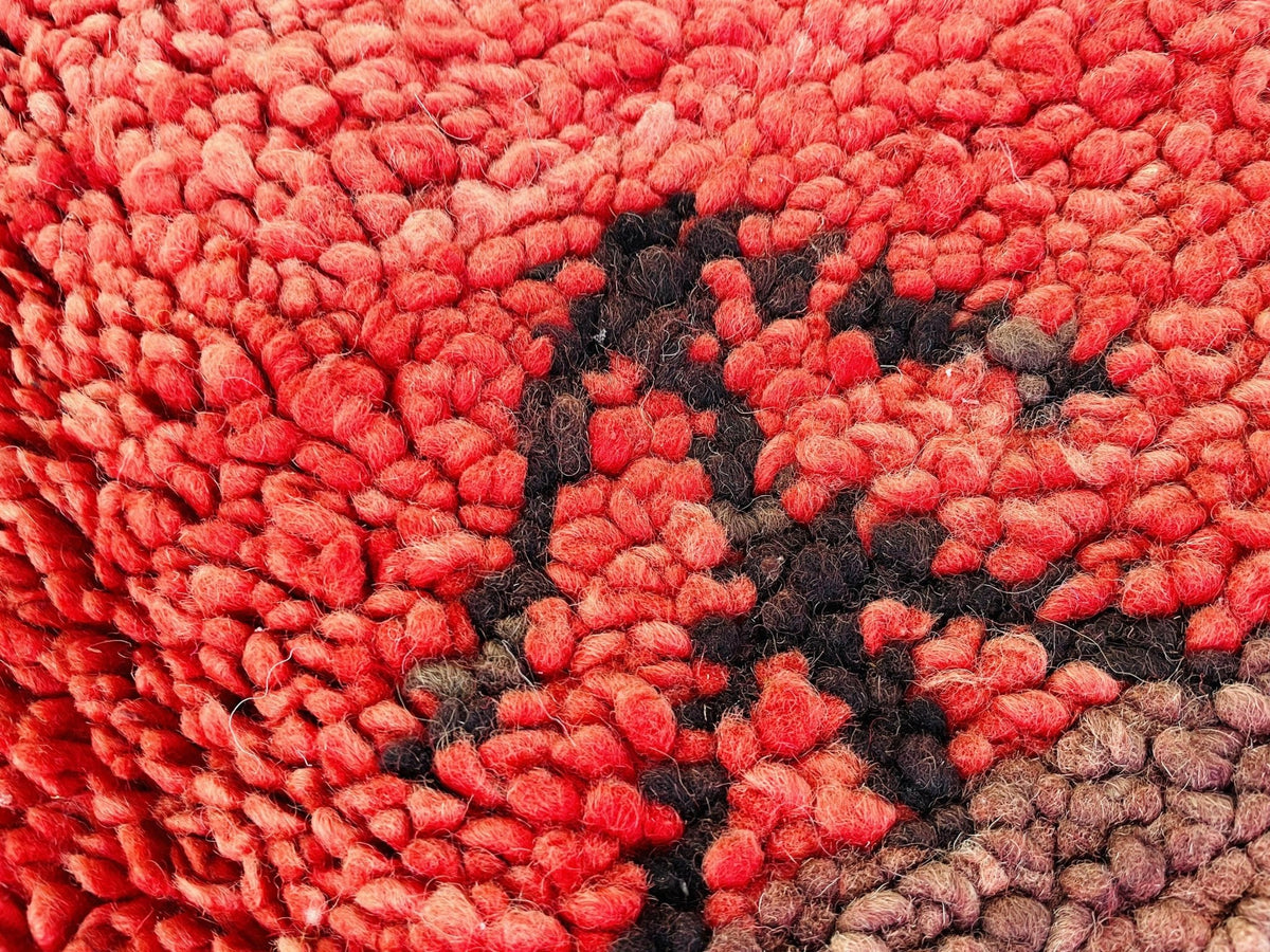 Close-up of the tribal patterns and textured surface of the red vintage Boujaad Moroccan rug.