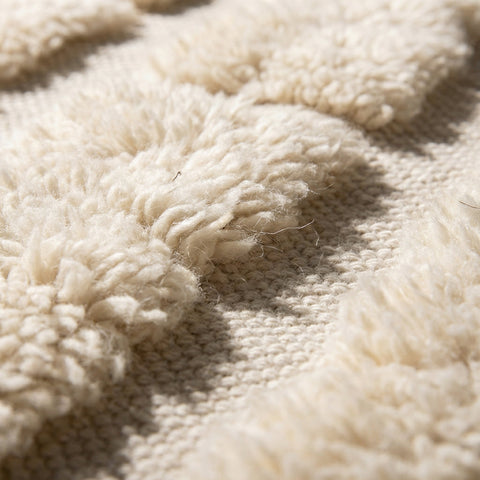 Front view of a beige Moroccan rug featuring a contemporary pattern against a solid backdrop.