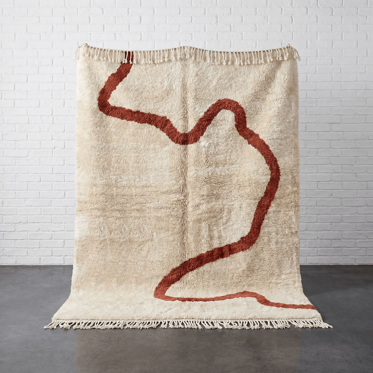 Front view of a beige Moroccan rug featuring an abstract pattern with red accents.