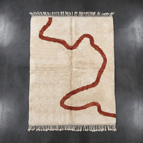 Front view of a beige Moroccan rug showcasing an abstract design with red highlights.