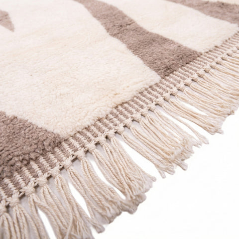 Close-up detail of the woven pattern and texture of the beige taupe rug.
