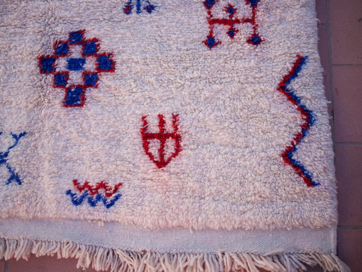Close-up detail of colorful patterns on a multicolor Beni Ourain rug with a textured surface.