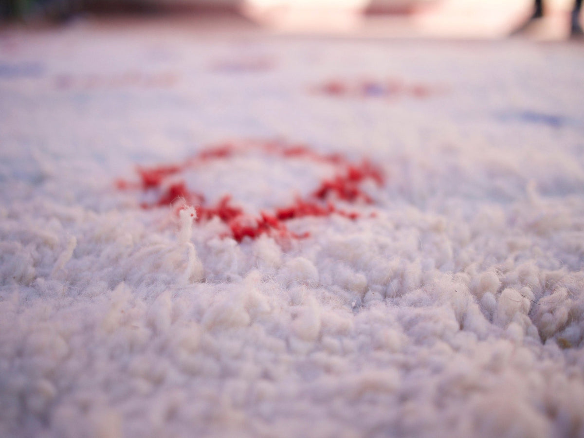 Close-up detail of a red square pattern on a multicolor Beni Ourain rug.