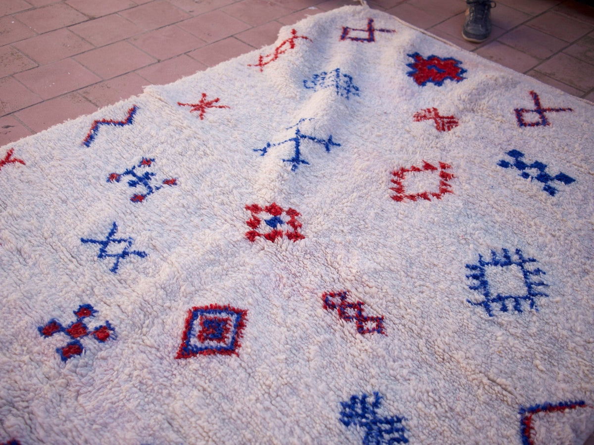 Close-up detail of the textured surface of a multicolor Beni Ourain rug featuring geometric patterns.