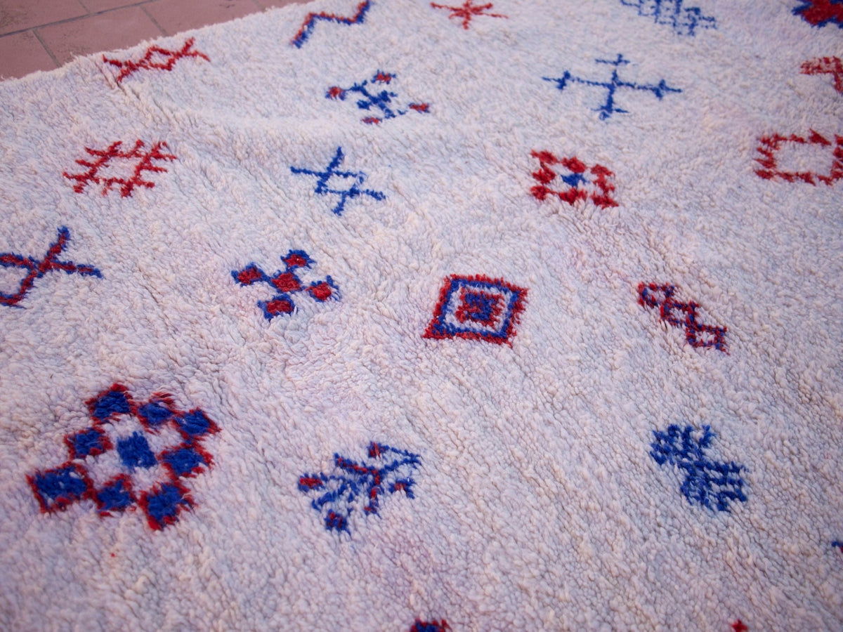 Close-up detail of a multicolor Beni Ourain rug showcasing its textured surface and geometric patterns.