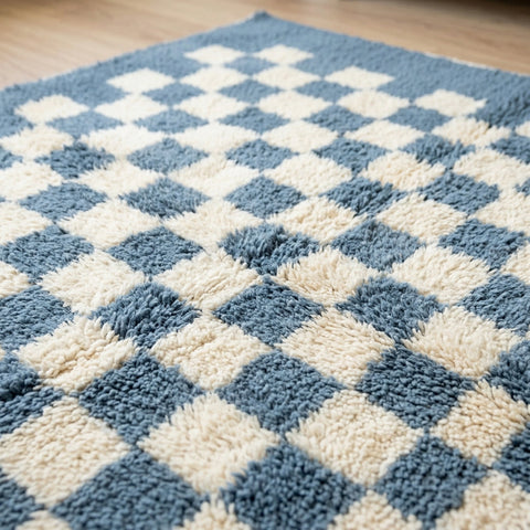 Detail shot of the blue checkered rug highlighting its textured surface.