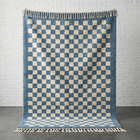 Front view of the blue checkered rug featuring fringe edges on a solid background.