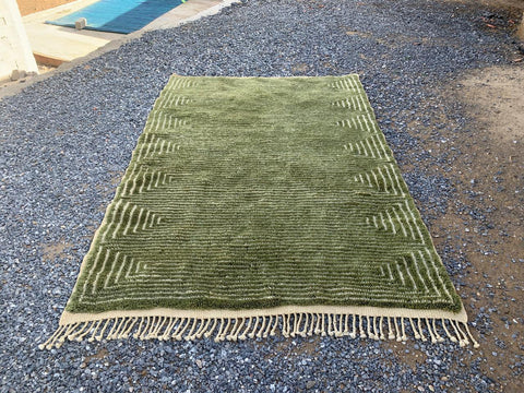Front view of the olive green Moroccan rug displaying its large size and fringed edges.
