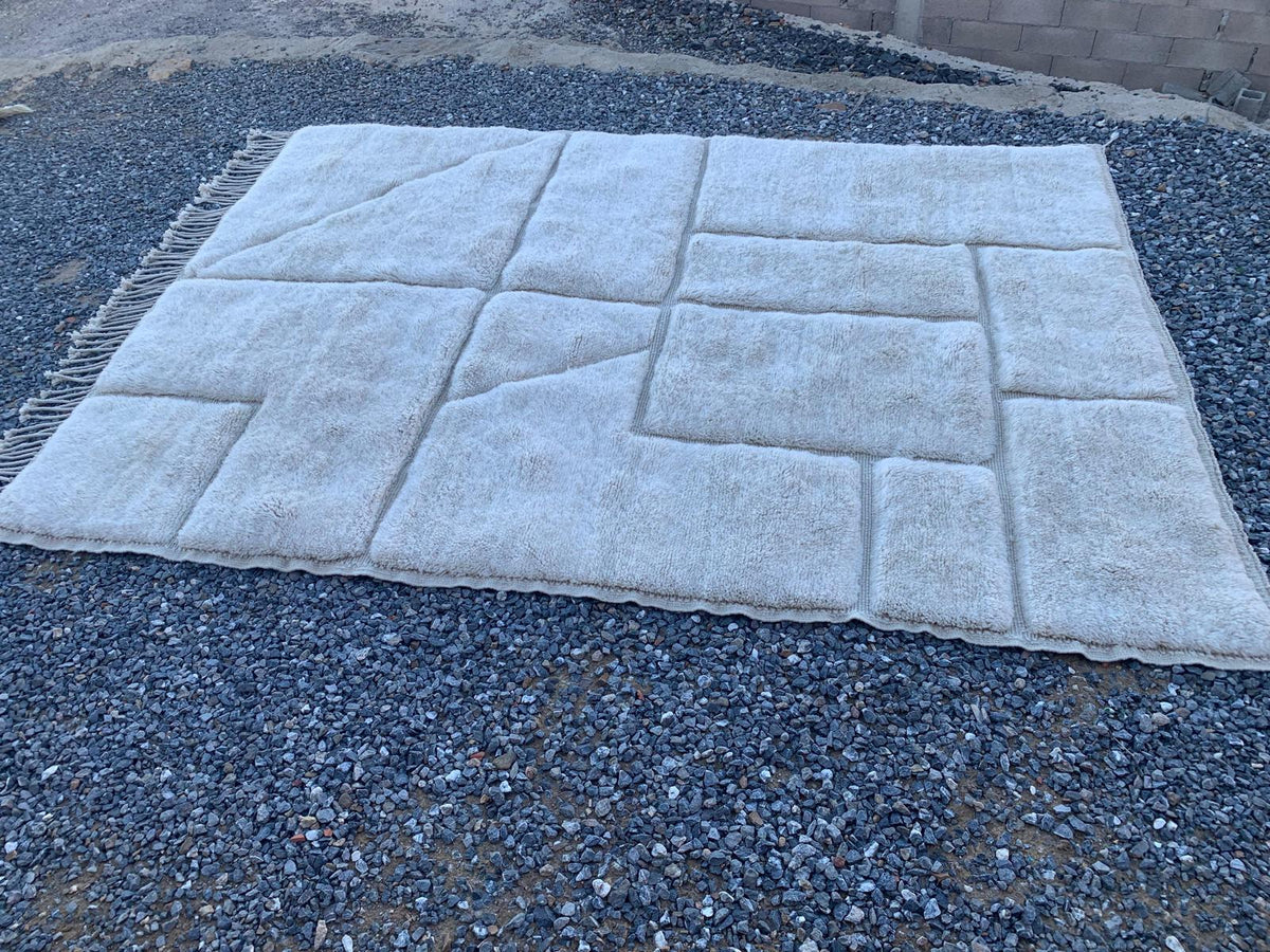 Close-up of a Moroccan rug with a geometric pattern in white and gray tones.