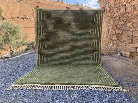 Front view of the olive green Moroccan rug showcasing its large size and fringed edges.