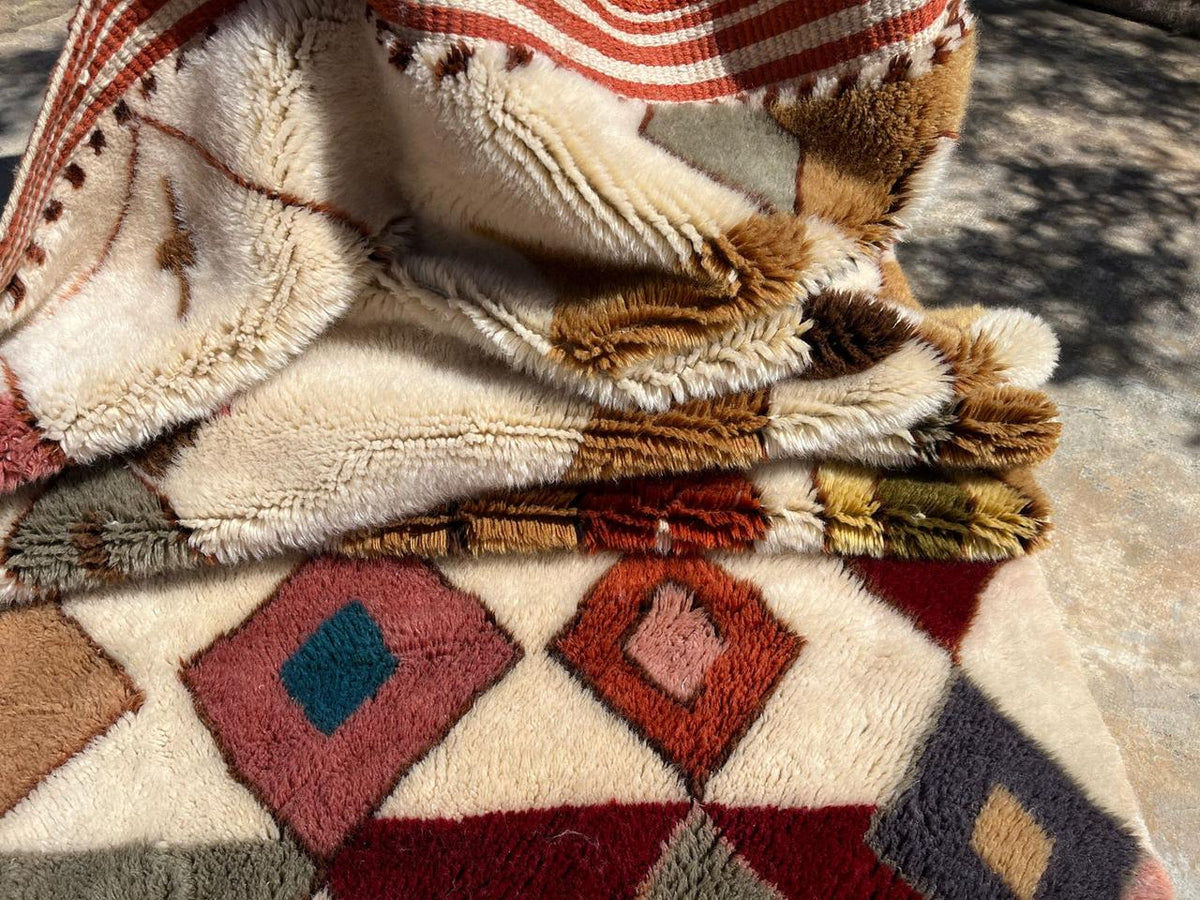 Close-up detail of the geometric patterns on the orange and black Mrirt rug.
