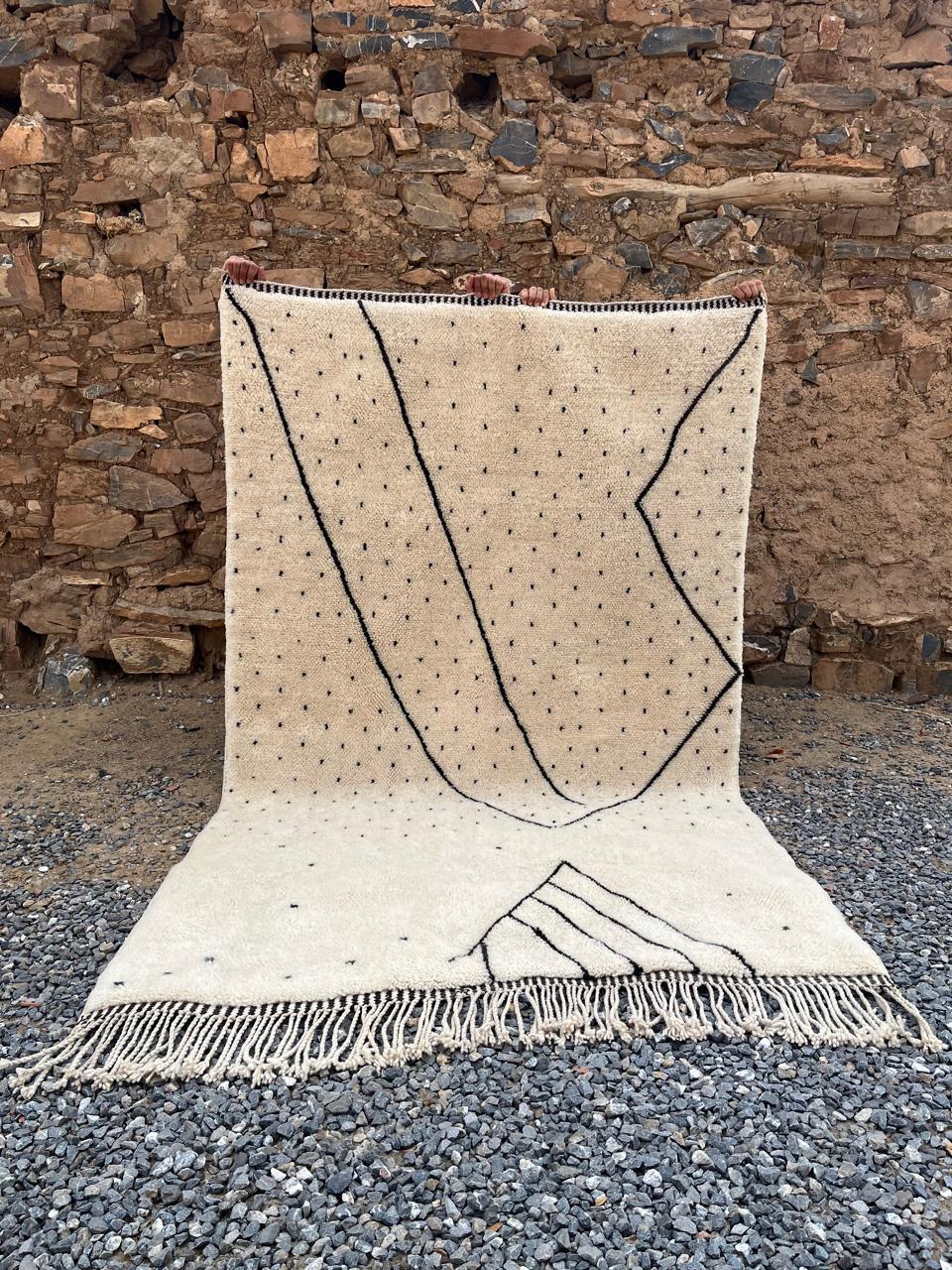 Front view of a cream and beige Berber Moroccan rug featuring an abstract pattern and fringed edges.