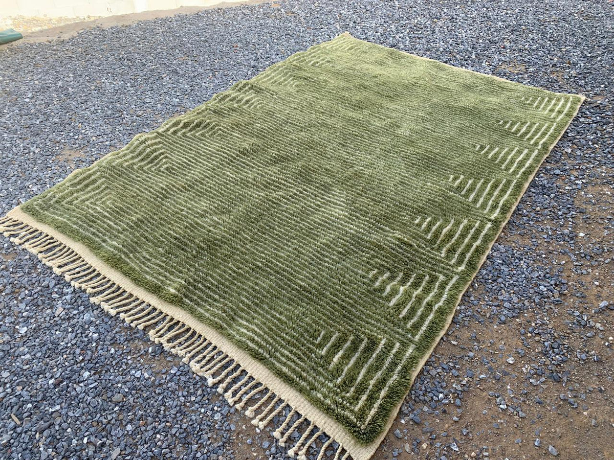 Front view of the olive green Moroccan rug featuring its large size and fringed edges.