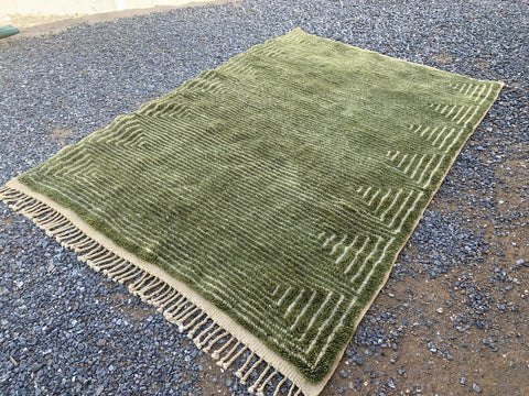 Front view of the olive green Moroccan rug featuring its large size and fringed edges.