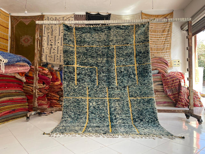 Lifestyle shot of a vintage Moroccan rug featuring geometric patterns in blue and yellow.