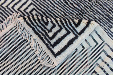 Detail shot of a black and white rug showcasing its geometric pattern and textured surface.