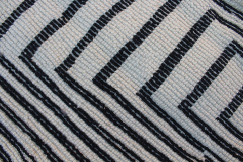 Close-up detail of a black and white rug with a zigzag pattern and soft texture.