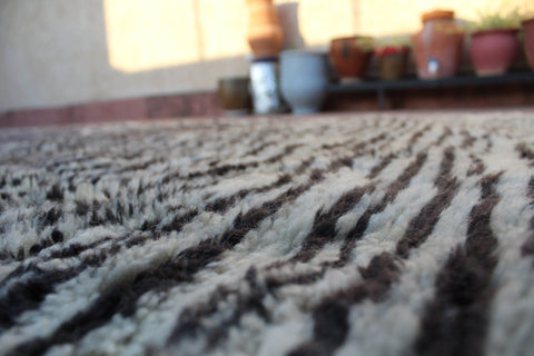 Lifestyle shot of a textured black and white rug in a natural setting.