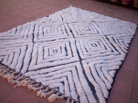 Close-up detail of a textured surface with a geometric design on a black and white rug.
