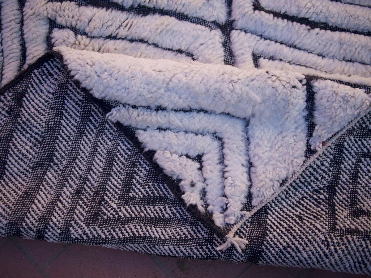 Close-up detail of a geometric pattern and soft texture on a black and white rug.