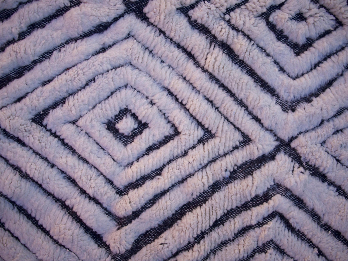 Close-up detail of a zigzag pattern and textured surface on a black and white rug.