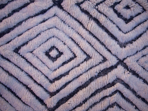 Close-up detail of a zigzag pattern and textured surface on a black and white rug.