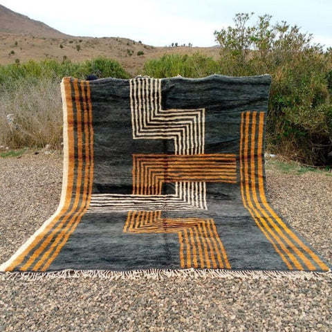 Lifestyle shot of the Black & Gold Geometric Custom Mrirt Moroccan Rug featuring a geometric pattern and textured surface.