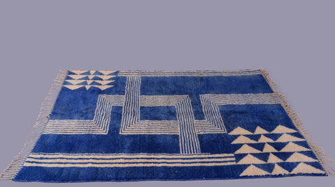 Side view of a blue Moroccan rug showcasing a thick pile and geometric patterns against a natural backdrop.