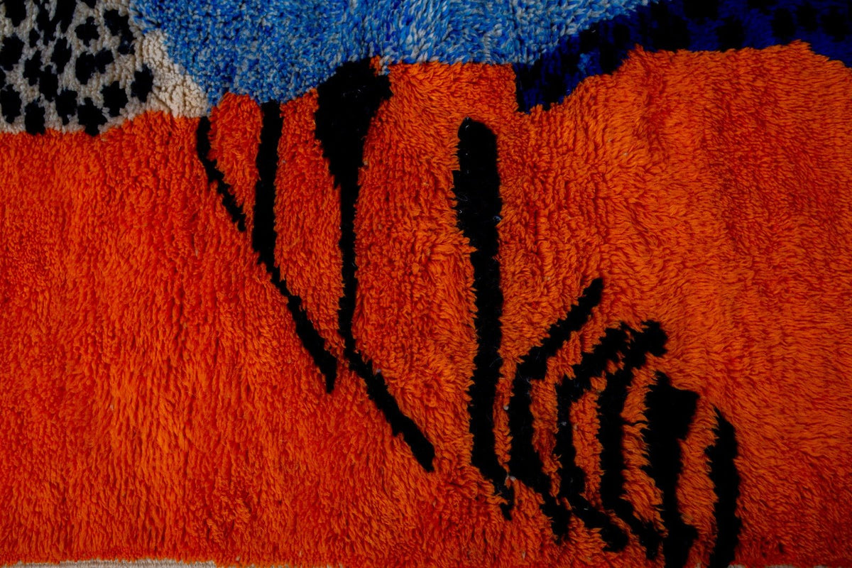 Detail view of a blue Moroccan rug featuring an abstract design and textured surface.