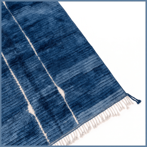 Front view of a blue Moroccan rug showcasing a geometric design on a studio background.