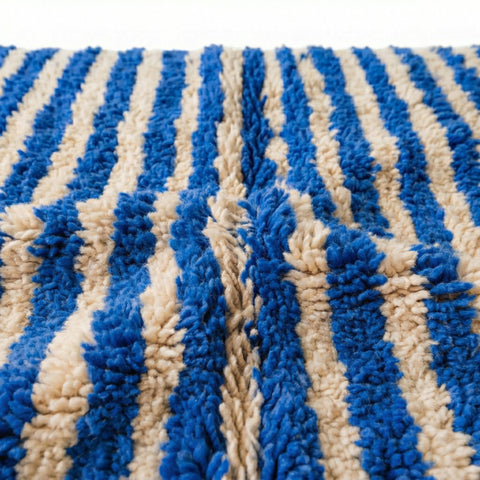 Close-up detail showing the soft texture and striped pattern of a blue Moroccan rug.