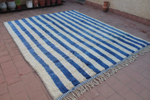 Lifestyle shot of a striped Moroccan rug in a natural environment.