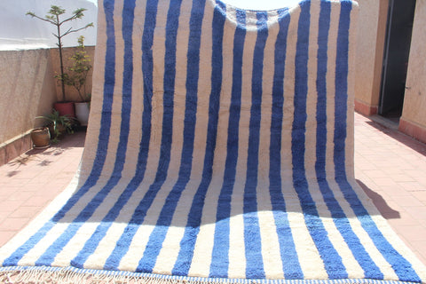 Lifestyle shot of a large blue striped Moroccan rug.