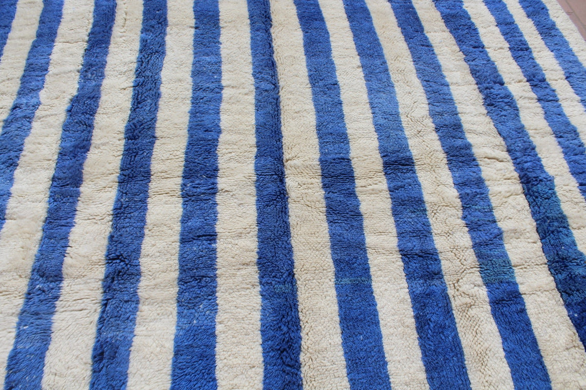 Close-up of a blue striped rug focusing on the striped pattern.