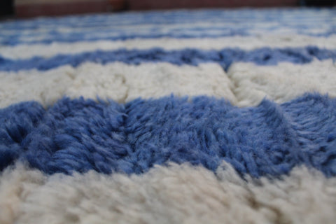 Close-up of a blue striped Moroccan rug showcasing its striped pattern.
